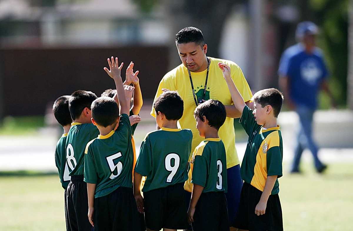 A coach discusses football with youths